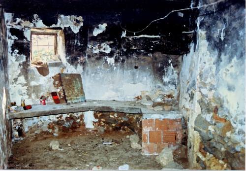 Original smoke blackened kitchen. Conctrete work suface and fireplace.